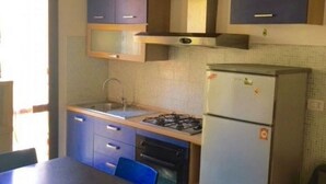 A compact kitchen with a sink, stove, and refrigerator, with cabinets above and below the countertop. - N186 - Numana, new two-room apartment with swimming pool (Maratta)
