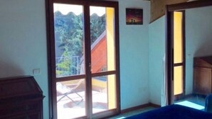 A room with a large sliding glass door leading to an outdoor area, a wooden ceiling, and a small painting on the wall. - N186 - Numana, new two-room apartment with swimming pool (Maratta)