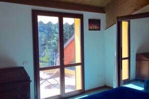 A room with a large sliding glass door leading to an outdoor area, a wooden ceiling, and a small painting on the wall. - N186 - Numana, new two-room apartment with swimming pool (Maratta)