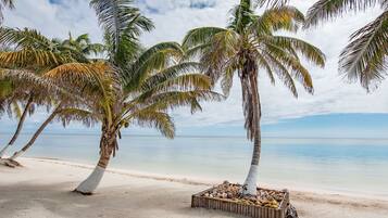 On the beach, white sand, sun loungers, beach towels