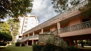 Un edificio de varios pisos con un patio central, que incluye una escalera y un balcón con barandillas decorativas.