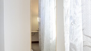 A narrow hallway with a door leading to a bathroom, featuring a toilet and a sink. - S220 - Sirolo, three-room apartment in the center with terrace (Sirolo)