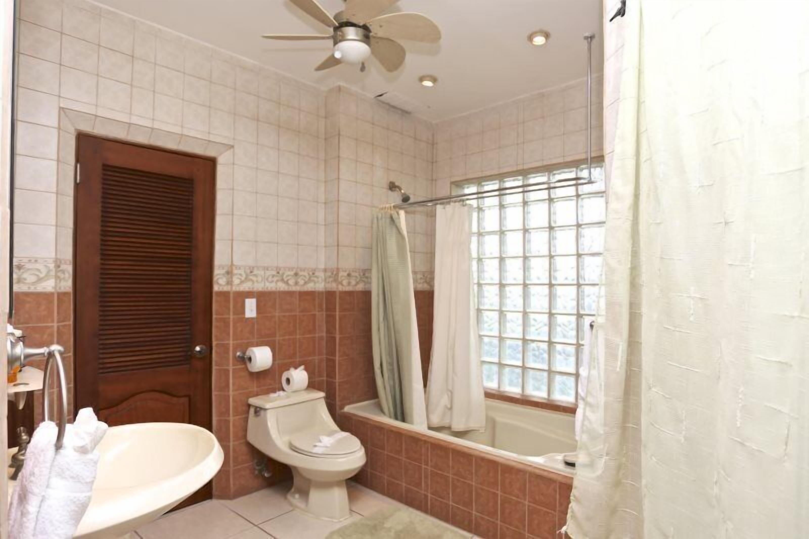 A bathroom with a toilet, sink, and bathtub.