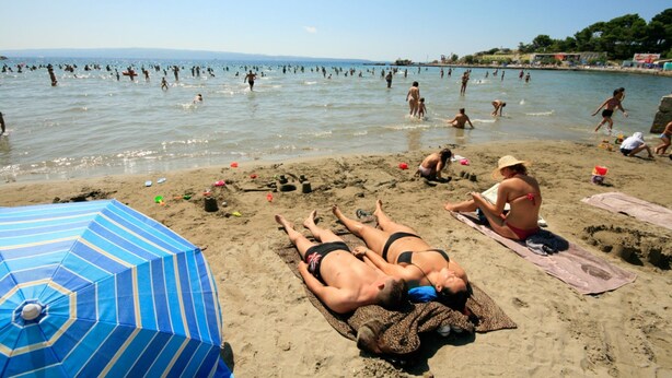 A beach with people sunbathing and swimming. - Apartment Antea (Split)