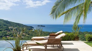 A poolside area with lounge chairs and a view of the ocean. - Cinco Sinsotes (Sardinal)