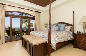 A four-poster bed with a floral bedspread, a wooden nightstand, and a bench. - Cinco Sinsotes (Sardinal)
