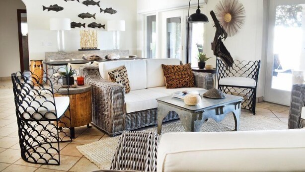 A living room with wicker furniture, a white sofa, and a coffee table. - Casa Oso Grande (Sardinal)