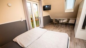 Une chambre à coucher avec un lit, un bureau et une télévision.