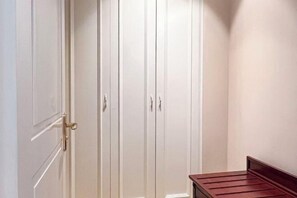 A room with a bed, a wardrobe, and a door.