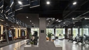 A modern gym with exercise equipment, large windows, and a minimalist design. - Minjiang Donghu Hotel (Meishan)