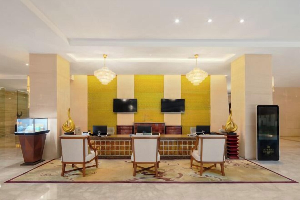 A reception area with a reception desk, two chairs, a television, and a large screen.