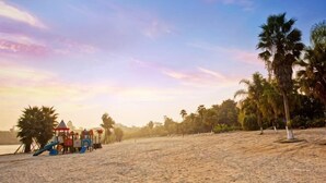 A sandy beach with palm trees and a playground. - Minjiang Donghu Hotel (Meishan)