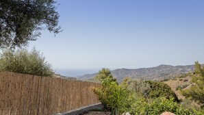 A view of a hillside with a wooden fence, a small garden with plants, and distant hills. - Cozy Holiday Home “La Monticana “ with Sea View, Wi-Fi, Air Conditioning, Pool & Terrace (Frigiliana)