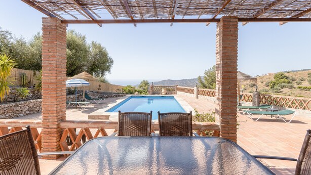 A covered outdoor area with a pool, wicker furniture, and a view of the landscape. - Cozy Holiday Home “La Monticana “ with Sea View, Wi-Fi, Air Conditioning, Pool & Terrace (Frigiliana)