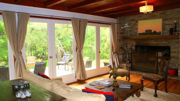 Una sala de estar acogedora con chimenea, asientos cómodos y ventanas amplias que ofrecen vistas al exterior.