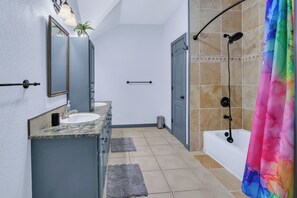 Un baño con lavamanos, espejo y ducha.