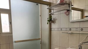 A bathroom with a toilet, sink, and glass shower enclosure. - Kinmen Good Friends (Jincheng)