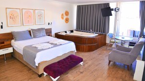 A hotel room with a bed, a bathtub, a desk, and a chair. - Mykonut Apart Hotel (Fethiye)