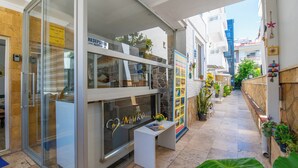 A reception area with a glass door, a reception desk, and a wall with a sign. - Mykonut Apart Hotel (Fethiye)