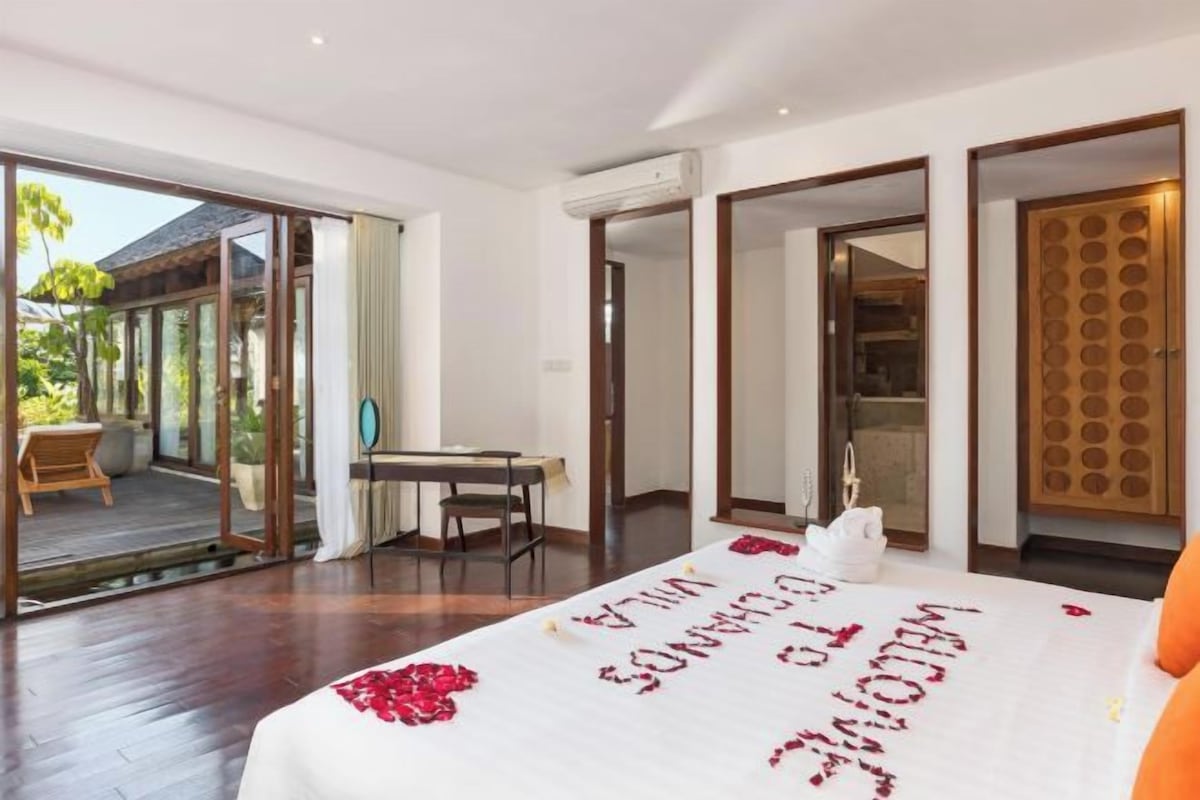 Quarto de hotel com cama, escrivaninha e vista para o exterior.