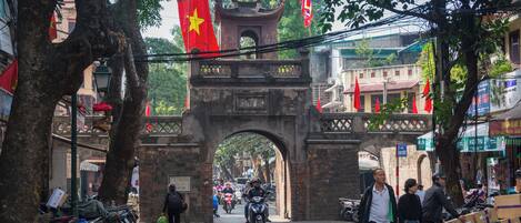 A street scene with a traditional archway, bicycles, and pedestrians.
