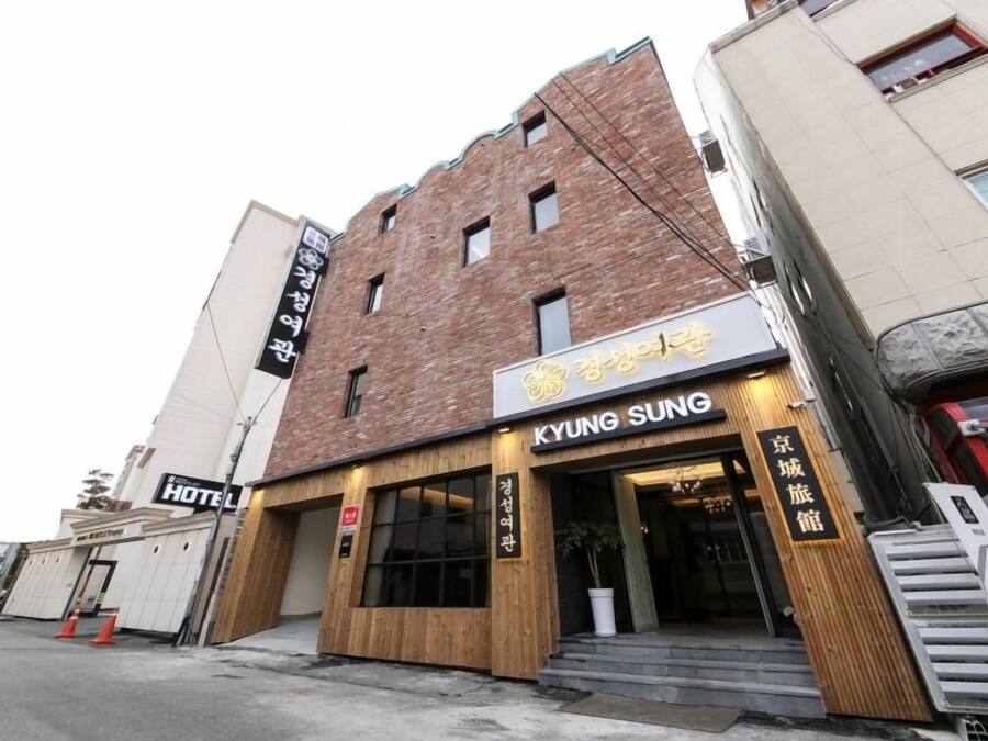 A hotel with a sign reading "KYUNG SUNG" and a wooden facade.