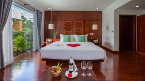A spacious bedroom with a large bed, wooden headboard, and a view of greenery through a large window. - Nita By Vo Private Pool (Siem Reap)