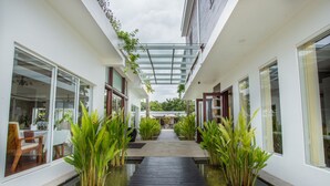 A modern building with a covered walkway, large windows, and indoor plants. - Nita By Vo Private Pool (Siem Reap)