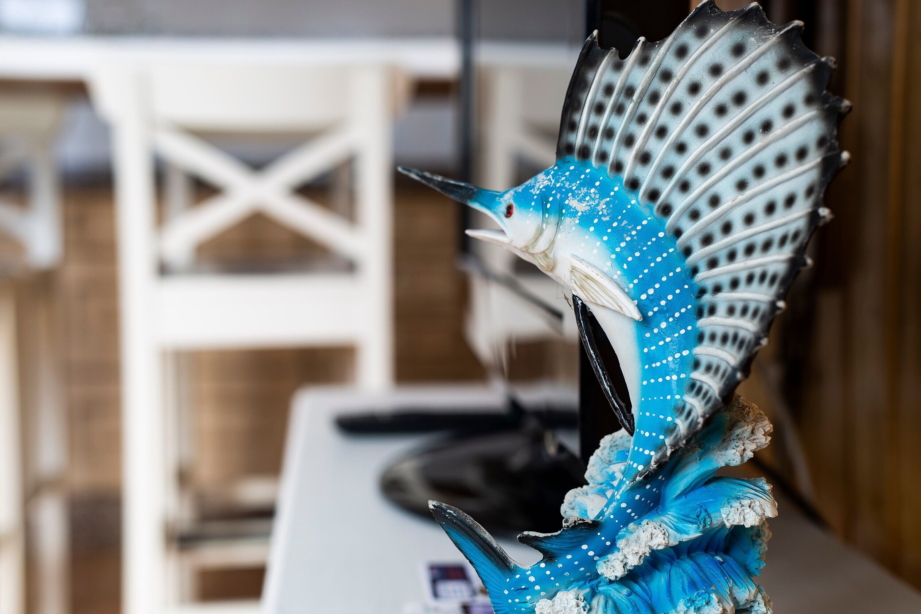 Een decoratief vissenbeeld met een blauw-wit patroon, geplaatst op een oppervlak.