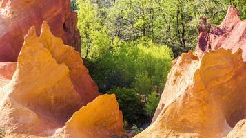 A natural landscape with prominent rock formations and dense green foliage.