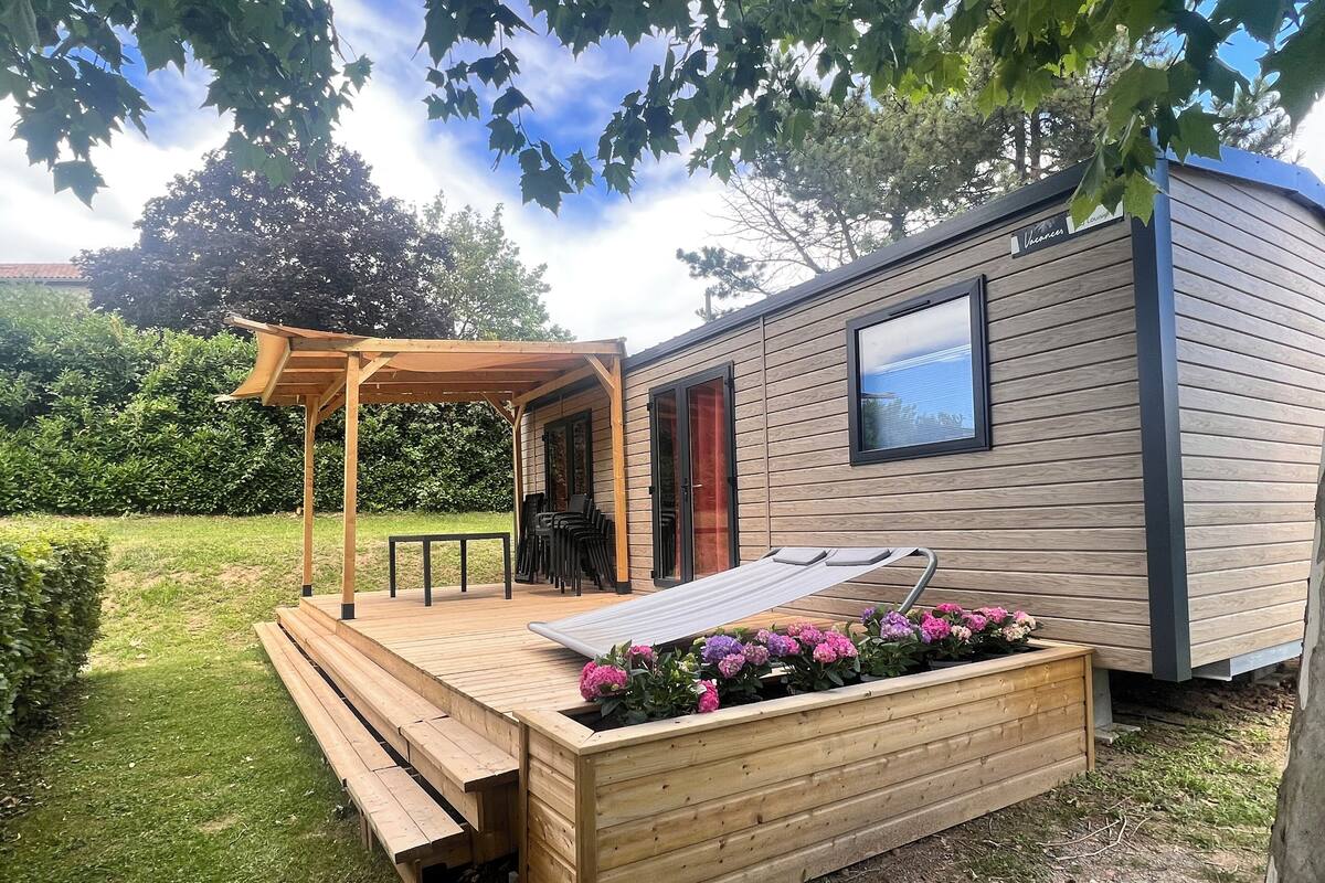 A wooden deck with a pergola, a bench, and a small table.