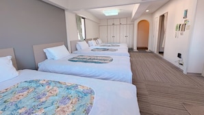 A hotel room with three beds, a carpeted floor, a wardrobe, and a telephone. - Weekly Green In Namba (Osaka)