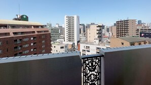 A cityscape with various buildings, including a prominent white building with a curved roof and a red brick building with multiple floors. - Weekly Green In Namba (Osaka)