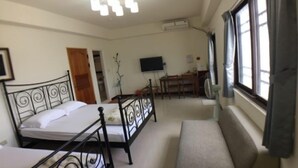 A bedroom with two beds, a sofa, a TV, and a window with curtains. - Penghu Happy Fish (Magong)