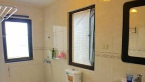 A bathroom with a toilet, sink, and window. - Penghu Happy Fish (Magong)