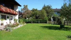 A well-maintained lawn with a house in the background.