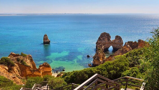 Paisaje costero con formaciones rocosas y mar azul cristalino.