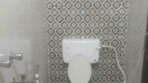 Een compacte badkamer met toilet, wastafel en douche.