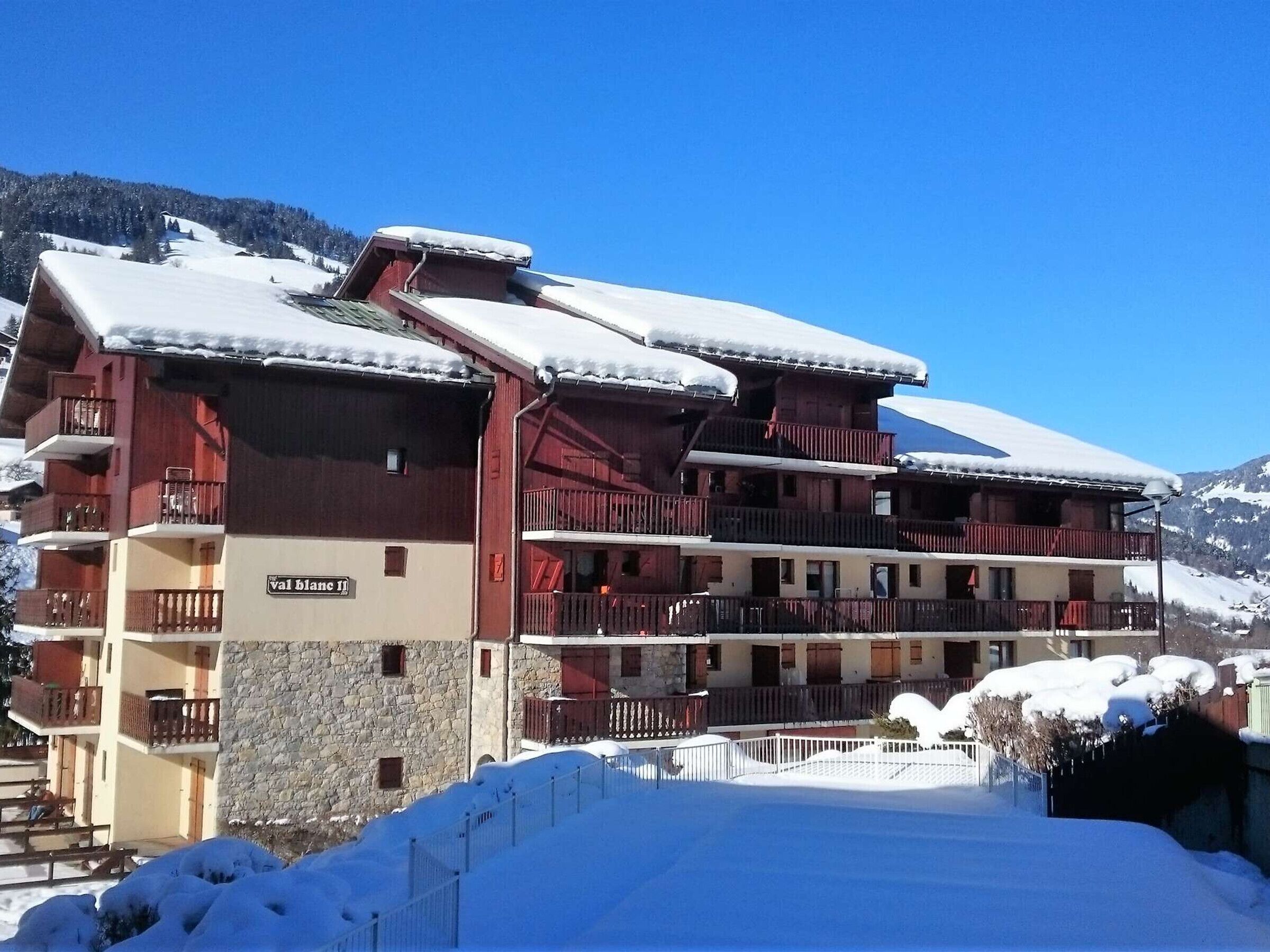 A multi-story hotel with balconies, a stone facade, and a sign reading "val blanc II".