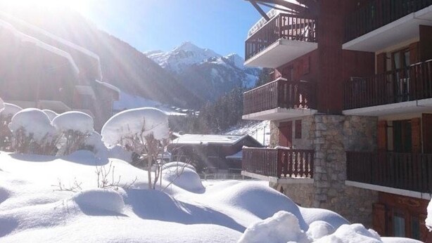 A multi-story building with balconies, surrounded by snow-covered terrain and mountains in the background. - Apartment for 5 with pool, balcony, close to ski and village (Arêches-Beaufort)