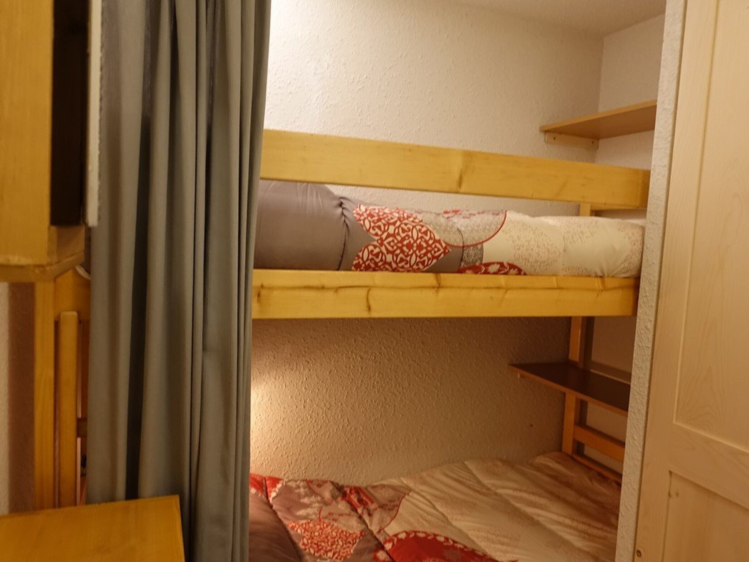 Ein Etagenbett mit unterem Bett und Schlafkabine oben.