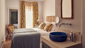 Un dormitorio con cama, un lavamanos azul, un espejo y una puerta.