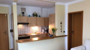 A compact kitchen with wooden cabinets, a countertop, and a sink. - No. 2 Apartment for 2-4 persons, 40 sqm (Prien am Chiemsee)