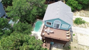 Une maison à deux étages avec une piscine, un patio doté de meubles d’extérieur et une terrasse.