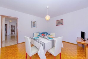 Ein Essbereich mit einem Tisch für vier Personen, Stühlen, einer Hängelampe und gerahmten Kunstwerken an den Wänden.