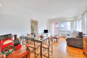 A modern living room with a dining area, a sofa, and a TV. - Kiki House (Lugano)