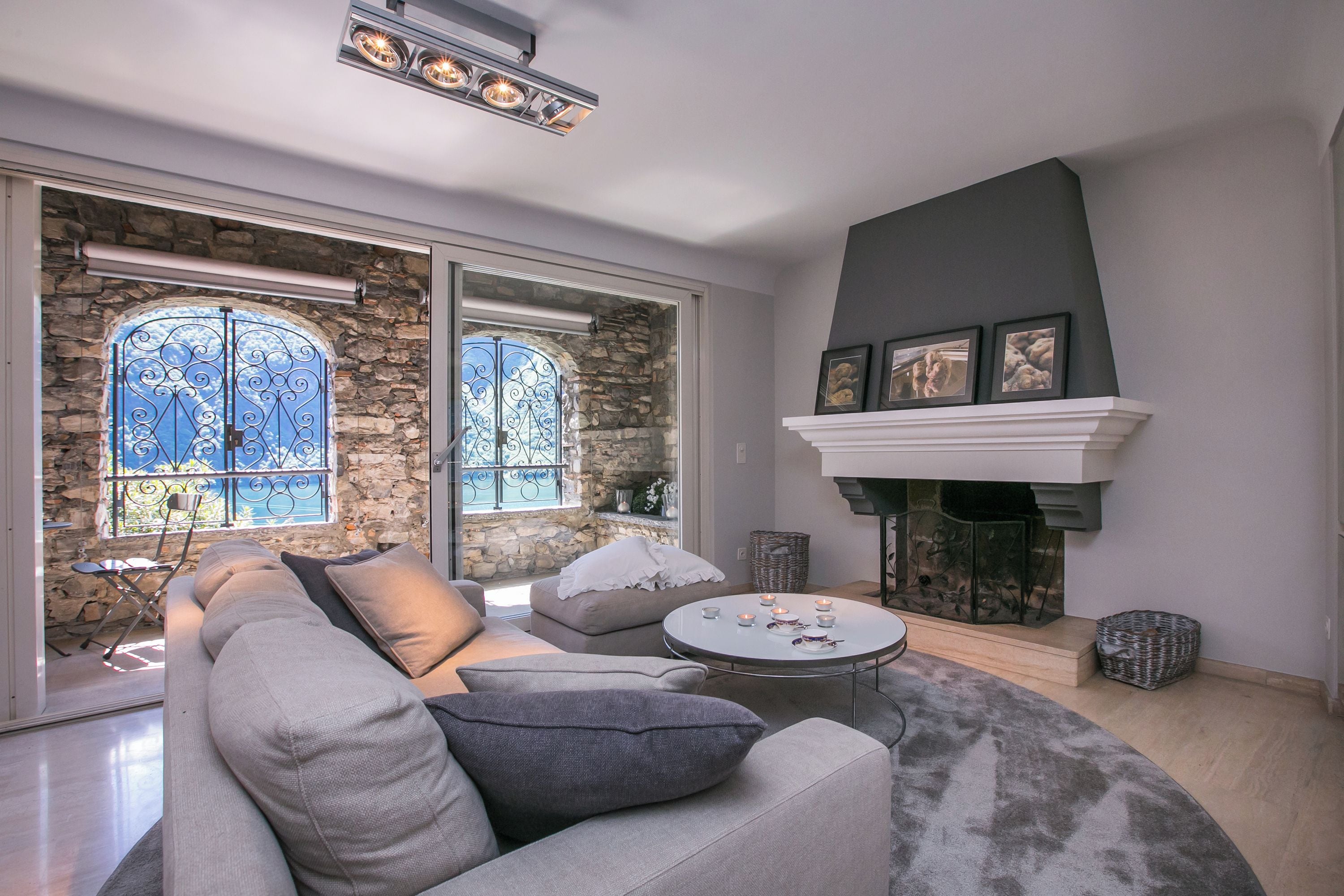 A modern living room with a stone wall, a fireplace, and a large window with a view.
