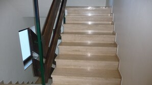 A staircase with wooden handrails and beige steps. - Apartment foresight (Steibis)