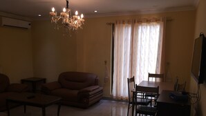 Un salon comprenant un canapé, une table basse, un téléviseur et une table à manger avec des chaises.