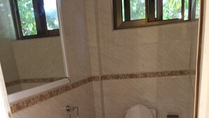 Une salle de bain avec un lavabo, des toilettes et un miroir.